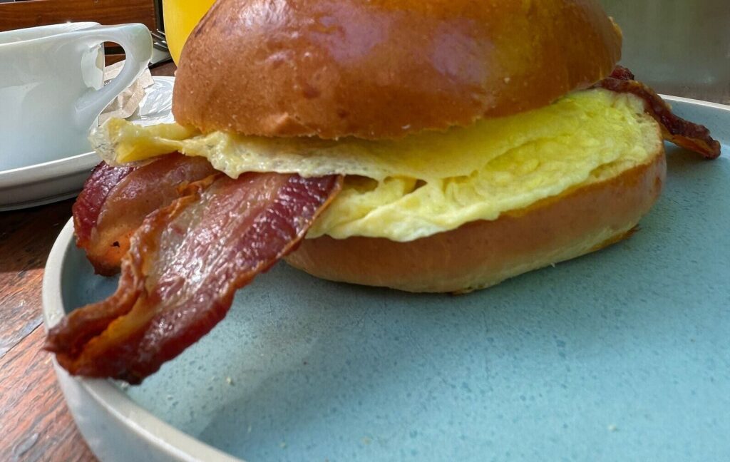 Bacon and egg bagel sandwich on a blue plate