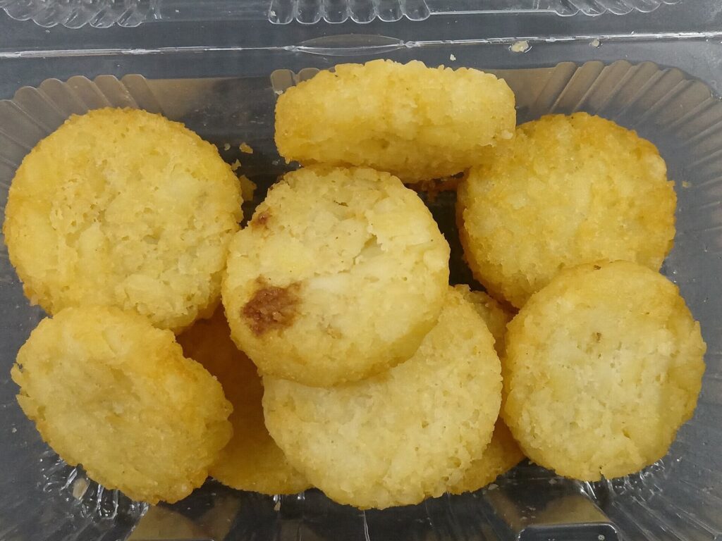Pile of crisp potato rounds in a clear container, seen from above