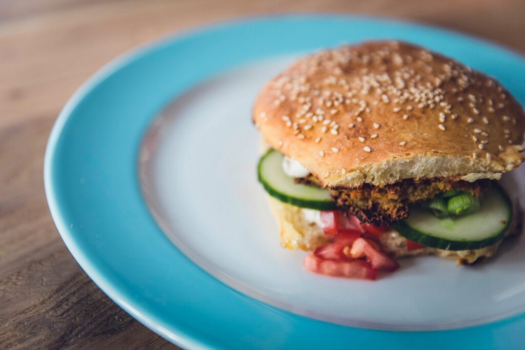 Tall cheeseburger stacked with guacamole, tomato and lettuce