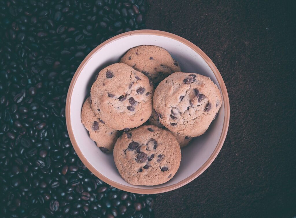 Chocolate chip cookies in a bowl on a bed of coffee beans