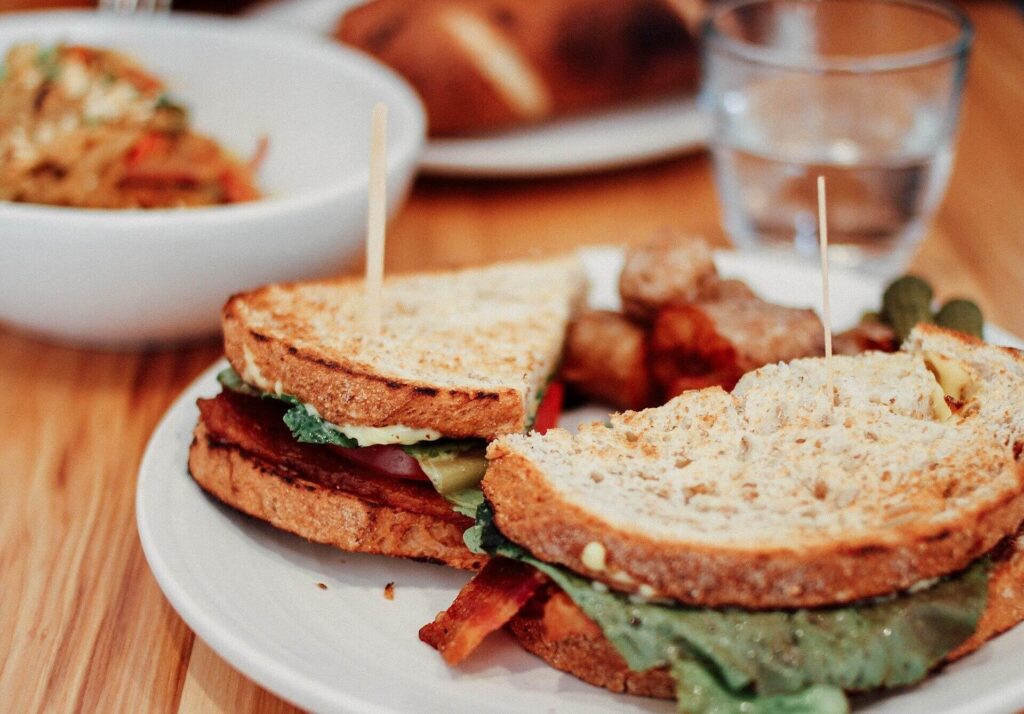 BLT on toasted bread with picks, roast potatoes behind